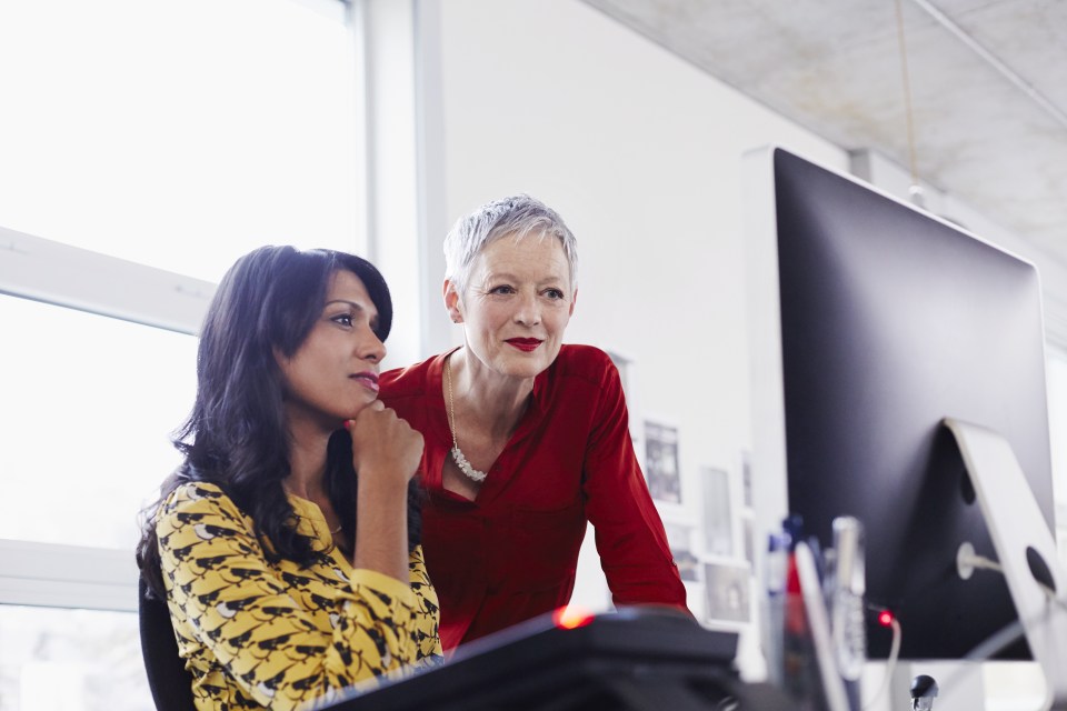 Mature business woman mentoring younger employee.