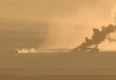  One of the armoured cars takes off in reverse while troops flee