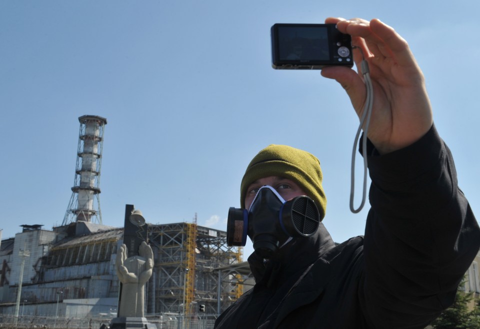 A visitor takes a selfie in front of the 4th power block of the Chernobyl Nuclear Power Plant 