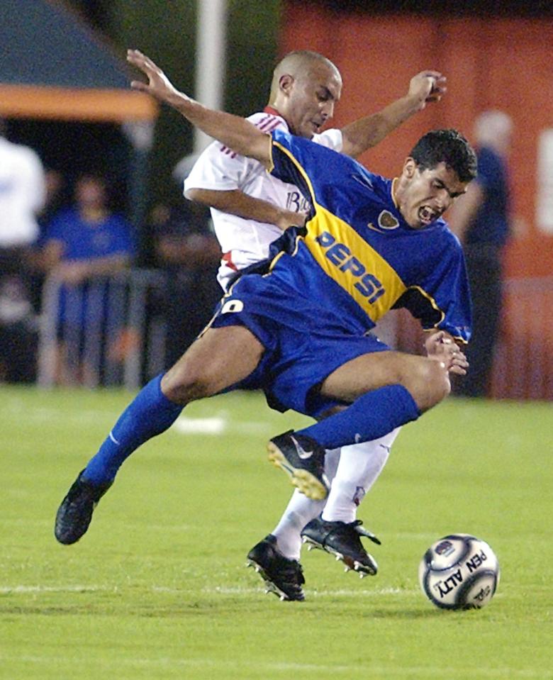 MIAMI, : River Plate's Matias LeQui (L) tries to muscle the ball away from Boca Juniors Carlo Tevez during first half action of their friendly match, 15 June 2002, at the Orange Bowl In Miami, Florida. AFP PHOTO/RHONA WISE (Photo credit should read RHONA WISE/AFP/Getty Images)