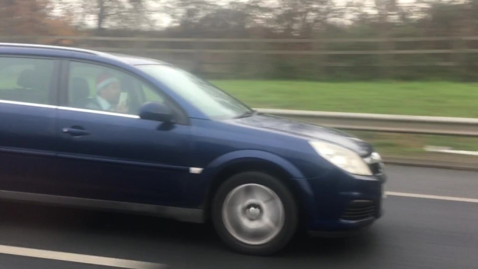 The driver quickly brought the phone down, away from his ear