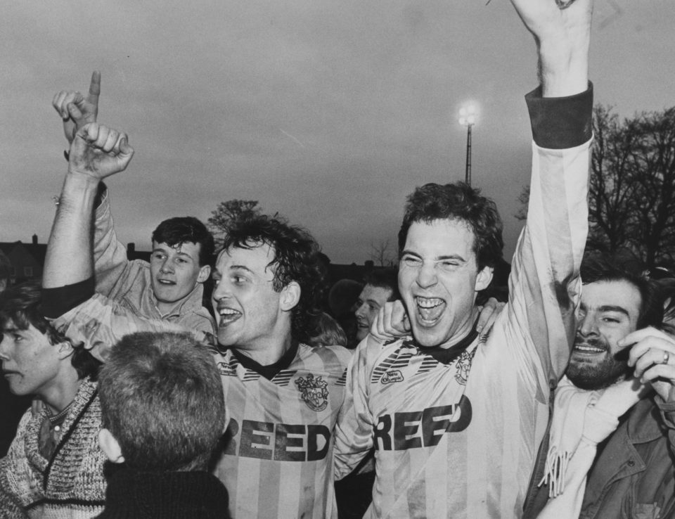  Sutton players, Paul McKinnon,(left) with Micky Stephens and fans on the pitch after the non-league team's stunning FA Cup third round win over holders Coventry City in 1989