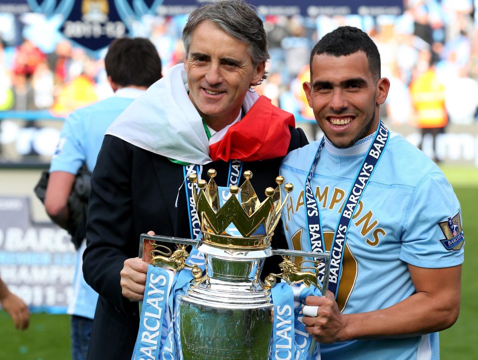 MANCHESTER, ENGLAND - MAY 13: (L-R) Roberto Mancini the manager of Manchester City and Carlos Tevez of Manchester City celebrate with the trophy following the Barclays Premier League match between Manchester City and Queens Park Rangers at the Etihad Stadium on May 13, 2012 in Manchester, England. (Photo by Alex Livesey/Getty Images)