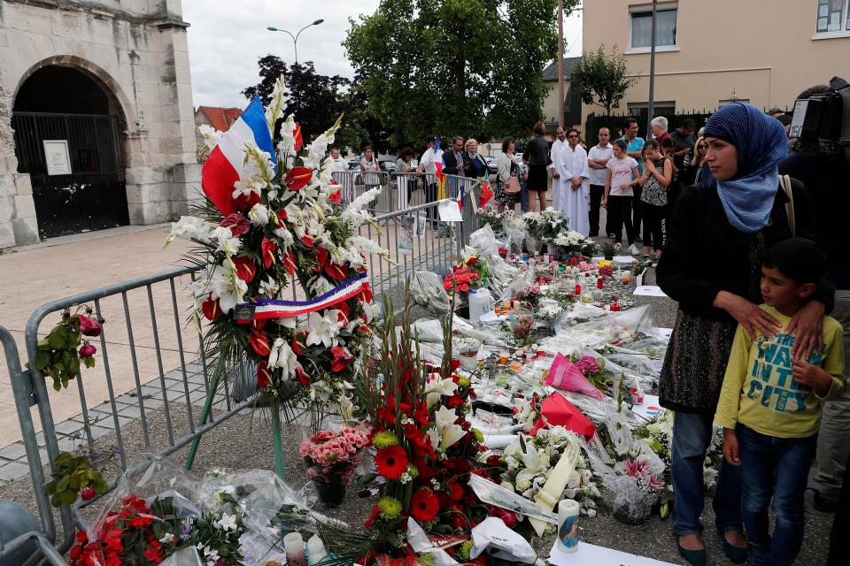  Worshippers gather in front of the memorial of the Saint Etienne church