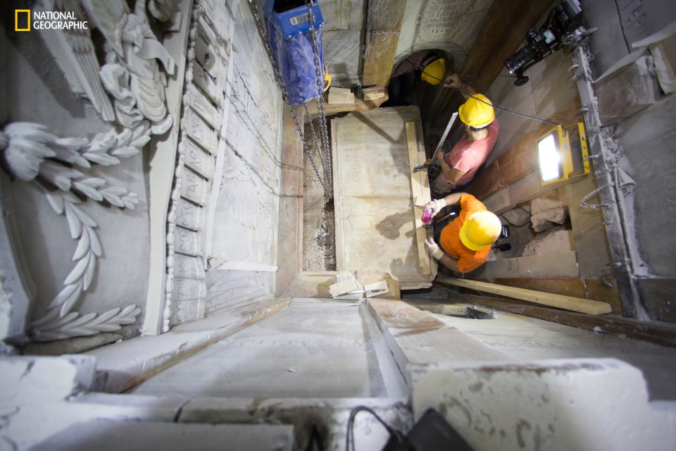 photo, shows the moment workers remove the top marble layer of the tomb 