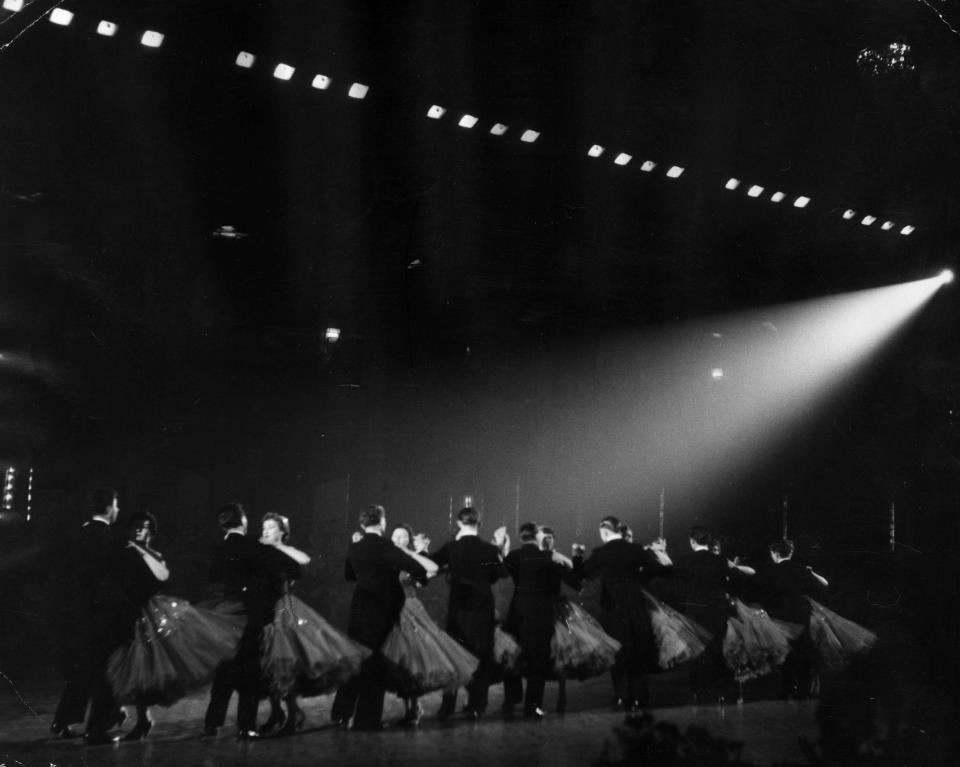  The spotlight shines on competitors as they take to the grand stage during a dance tournament in the 1950s