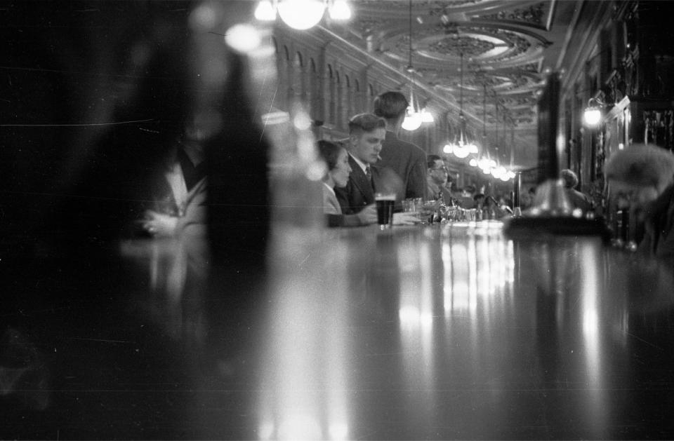  A partygoer rests his feet and enjoys a tipple at the Tower bar, which is the longest in Britain