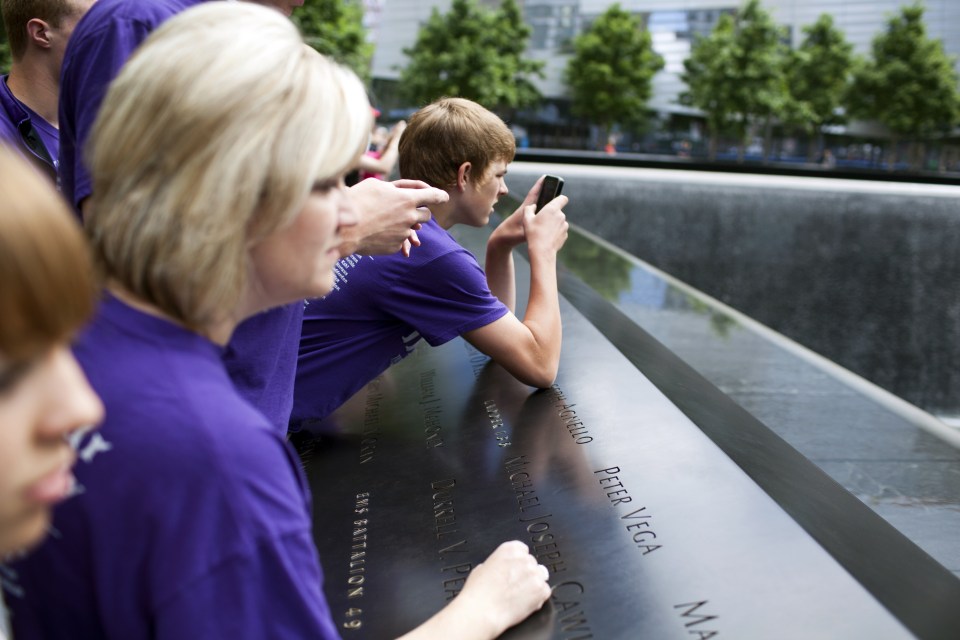 Tourists take pictures of the South Pool at the 9-11 Memorial in New York City