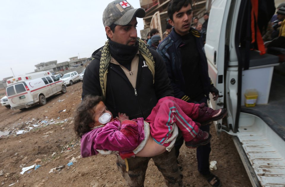  A wounded Iraqi girl is bundled into an ambulance during the latest skirmishes around Mosul