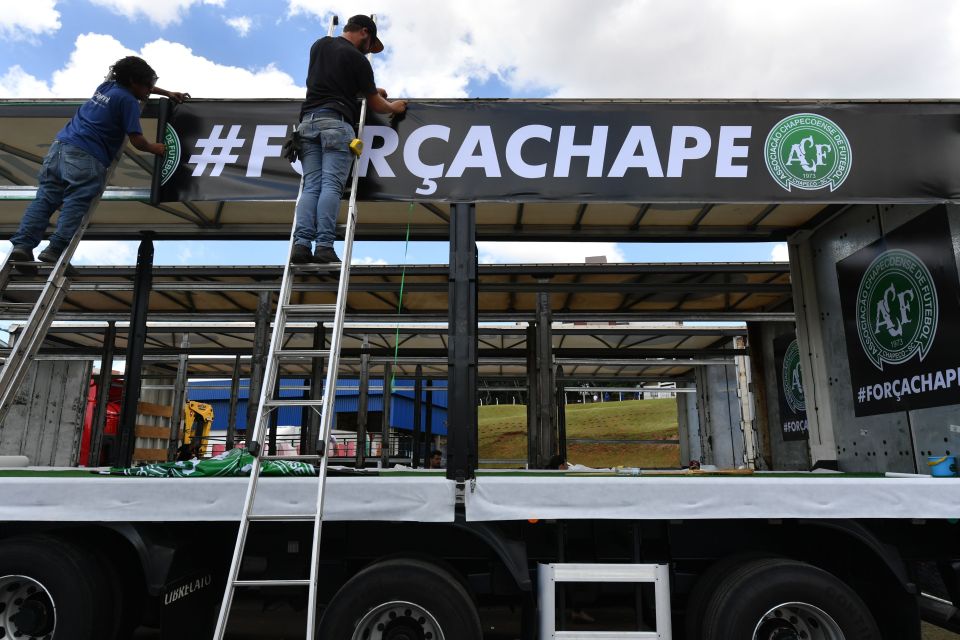 Men place a banner reading "Strength Chape" on a truck in which the coffins of Brazilian team Chapecoense will be transported in