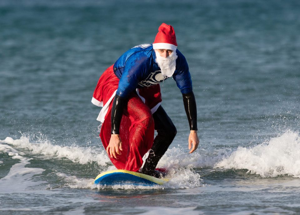 A surfing Santa gets to his feet as he braves the cold Cornish seas last weekend