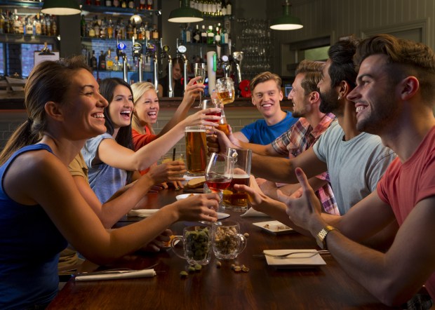 Group of friends enjoying food and drink in a bar.