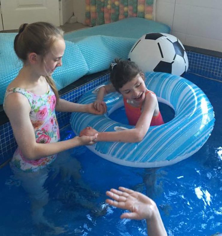 Jessica pictured during a swimming lesson with the help of her sister Olivia 