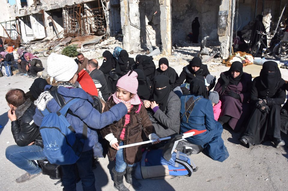  People who were evacuated from the eastern districts of Aleppo wait with their belongings in a government held area