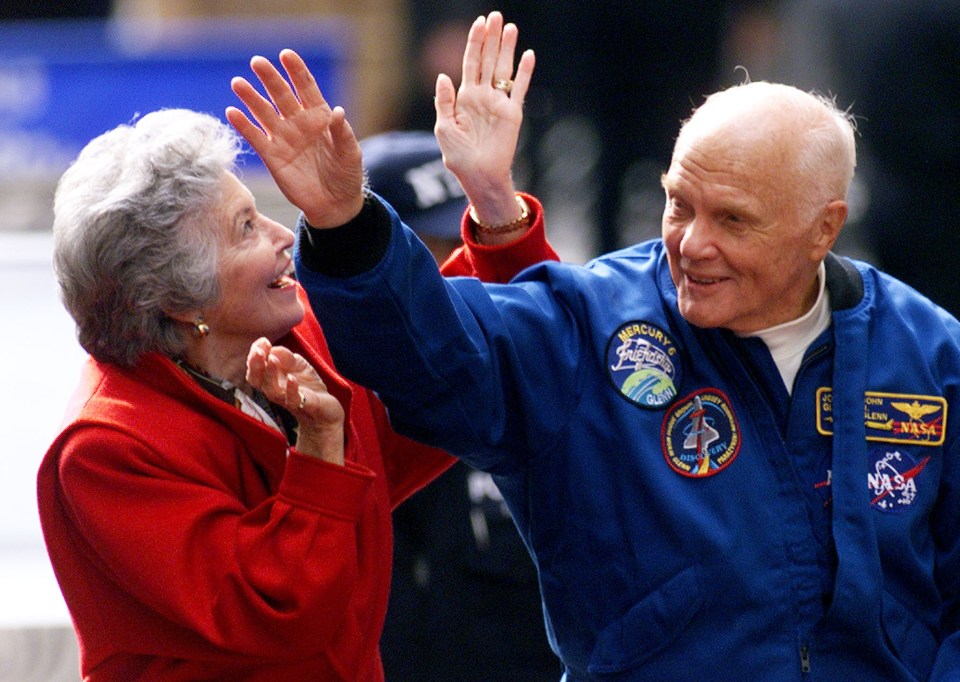  Astronaut John Glenn waves to the cheering crowd as he rides in an open car with his wife Annie during a ticker tape parade down New York's "Canyon of Heroes" in 1998