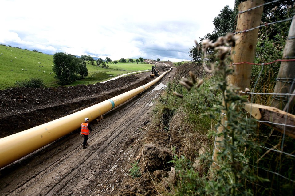 An engineer walks along a stretch of gas pipeline near Skipton in northern England