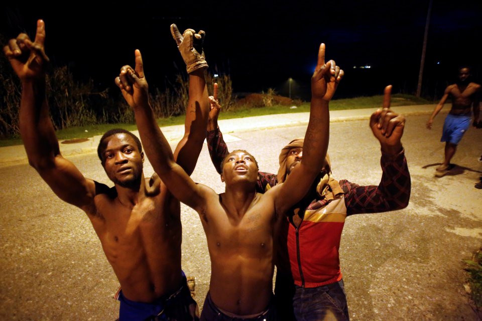  African migrants react after crossing the border fence