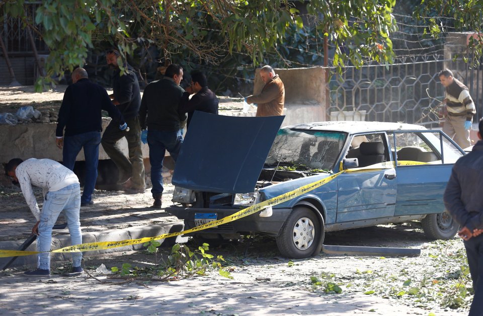 Security officials and investigators inspect the scene of a bomb blast, in Giza Al Haram Street, on the outskirts of Cairo