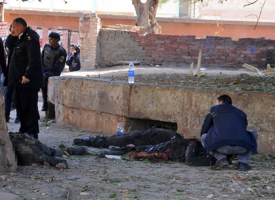  Egyptian emergency services attend to a wounded victim at the site of a bomb attack next to a police checkpoint