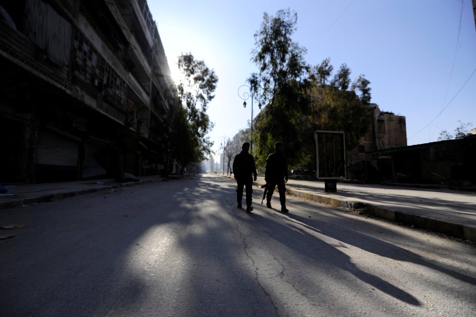  Forces loyal to Syria's President Bashar al-Assad walk along an empty road