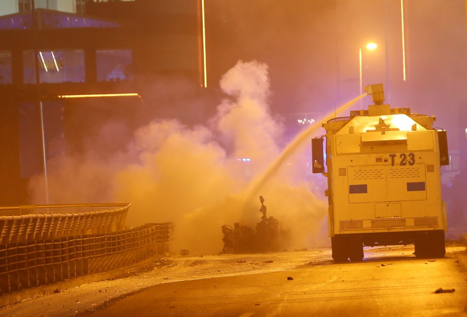 Police extinguish a burning car using a water cannon after a blast in Istanbul