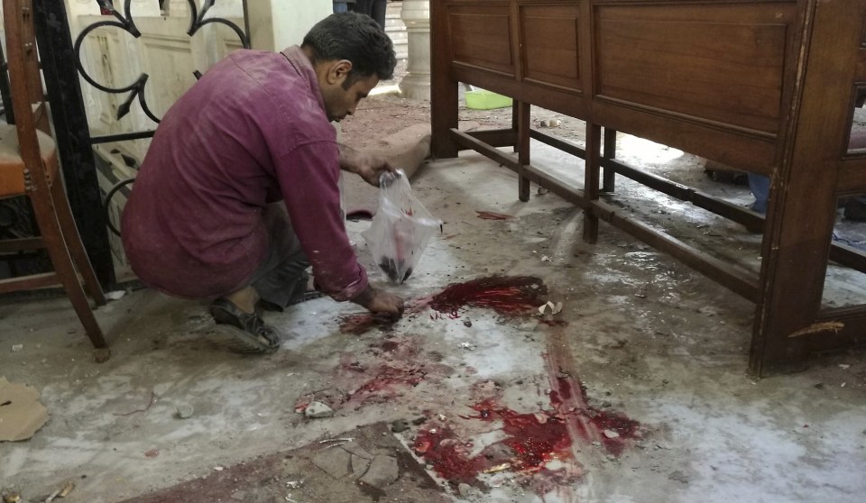 A worker cleans the scene inside St Mark Cathedral in central Cairo, following a bombing