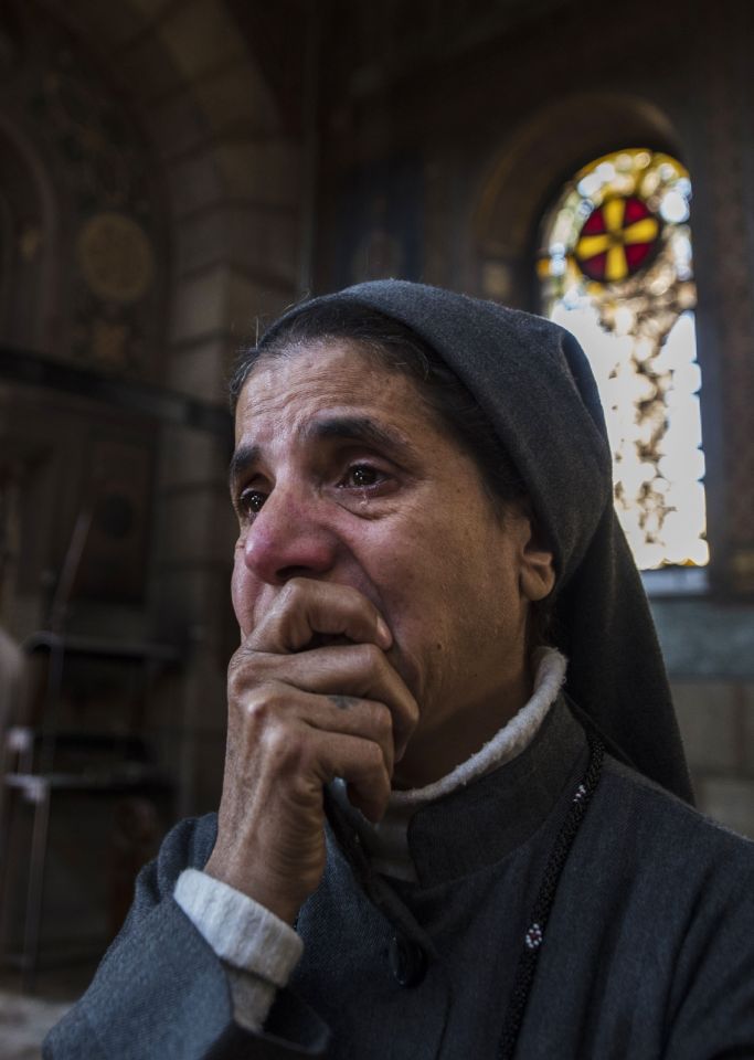 A nun reacts as Egyptian security forces inspect the scene of the bomb explosion