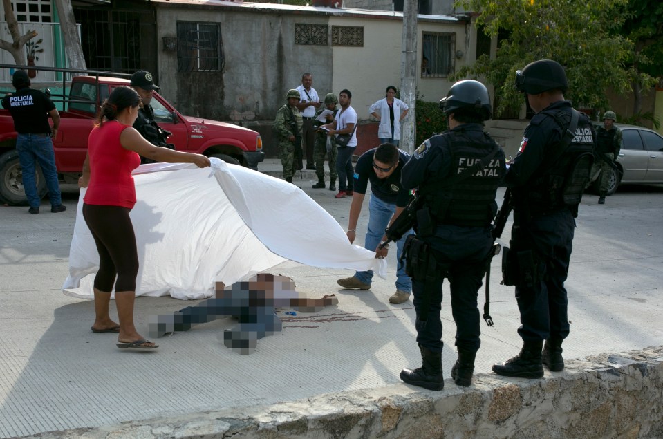  Officers place a sheet over the body of Alejandro Gallardo Perez, 23, after he was gunned down on the outskirts of Acapulco in April