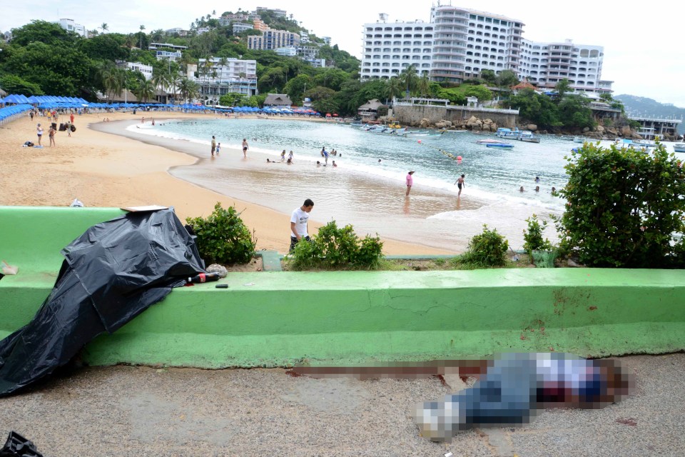  Two bodies lie where they were killed next to Caleta beach, in the Pacific resort city of Acapulco