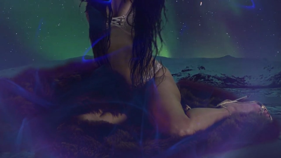 She moves around seductively to a background similar to the Northern Lights