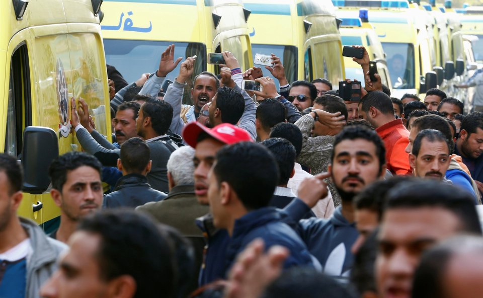  Egyptian Christians shout slogans and bang on the ambulances carrying the bodies of the victims after the funeral