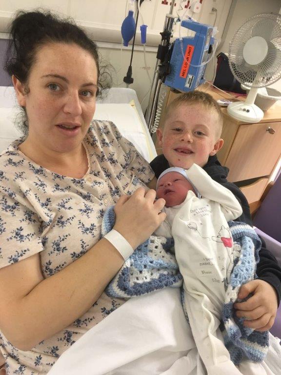  Little Noah, pictured with his mum Kelly and big brother Baily, was thankfully delivered happy and healthy despite the drama