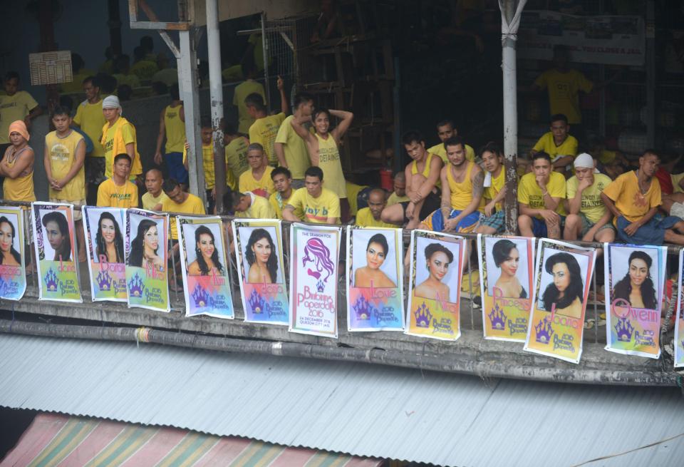  Detainees relax next to photos of gay inmates for a beauty contest inside the jail complex