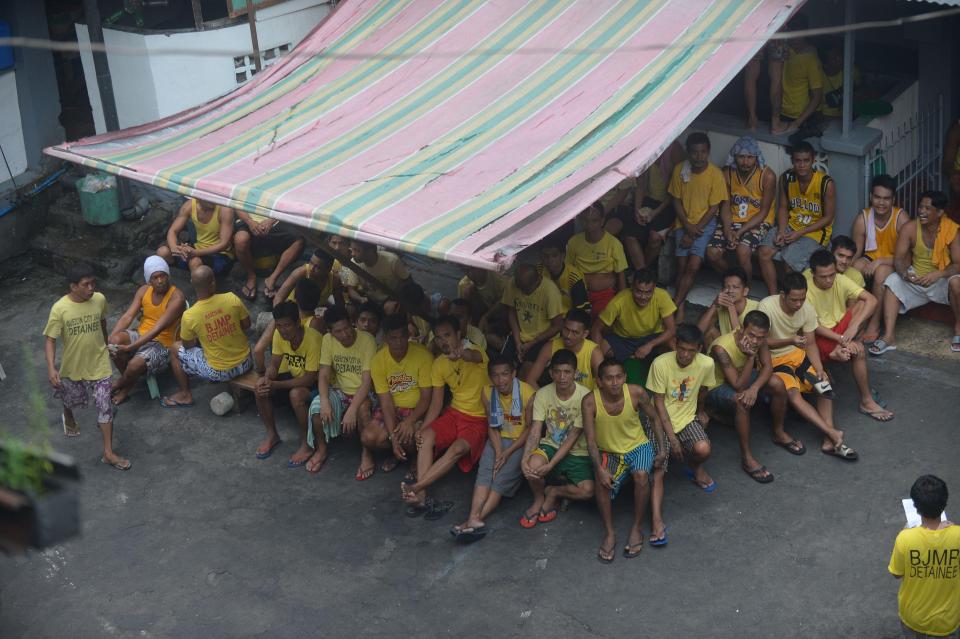  Prisoners gather under a shelter in the jail complex's courtyard