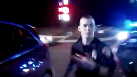  Another officer helps his injured colleague into the back of a police car