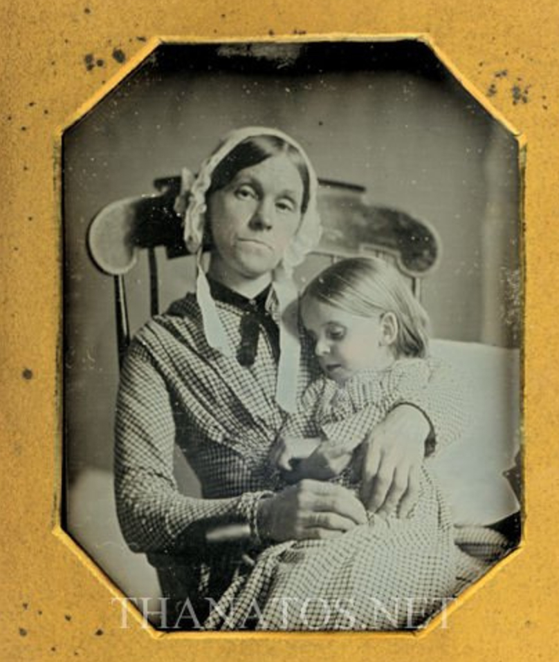  A mother cradles her dead daughter as she poses in matching clothing for a photograph taken in the 1840s