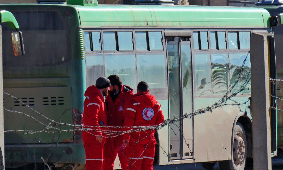  Staff of the Syrian Red Crescent stand next to buses which will be used to evacuate rebel fighters and their families from rebel-held areas of Aleppo. Paramedics (not pictured) were reportedly fired on