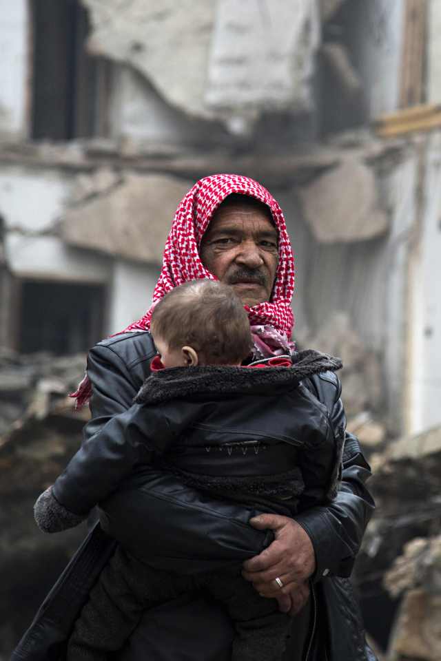  A civilian carries a boy towards the government-held side