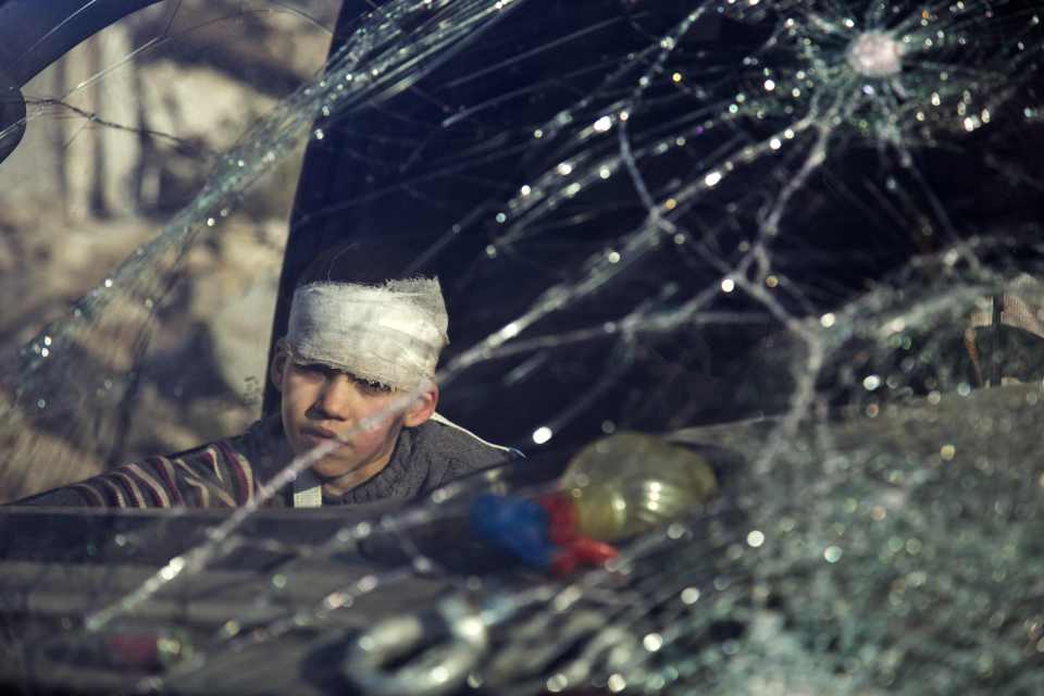  A wounded boy sits inside an ambulance. It has been reported that Syrian forces fired on a medical vehicle