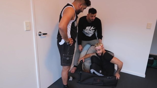 Vlogger Adam Saleh is zipped into a suitcase by his friends ahead of a plane journey from Melbourne to Sydney