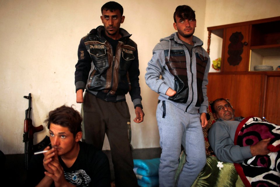  The brothers' father Hussein, right, lies in a small bed in the family's farm outside Mosul