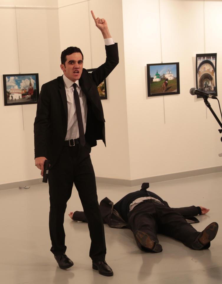 A man gestures near to Andrei Karlov, the Russian Ambassador to Turkey, on the ground, at a photo gallery in Ankara, Turkey