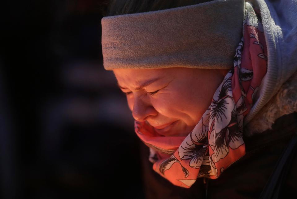 A woman breaks down in tears at the scene