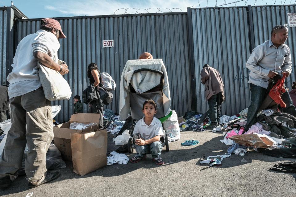 Boy waits for his mother to gather donated clothes, Towne Avenue