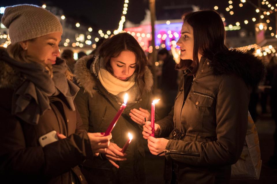 People hold candles to commemorate the victims of the terrorist attack in Berlin, at the Christmas market in Zurich, Switzerland