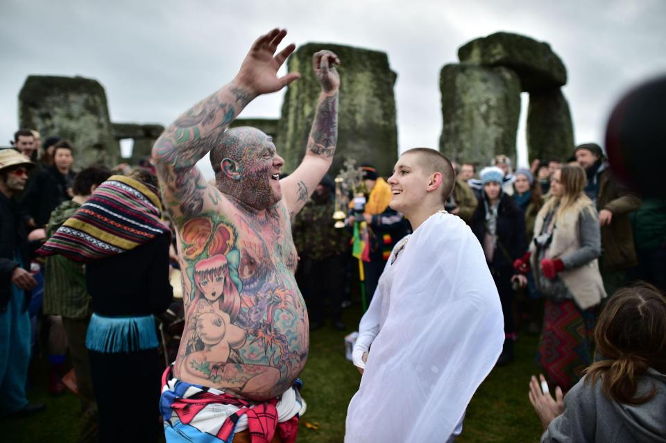  Heavily-tattooed reveller known as Mad Al celebrates the solstice alongside a woman clad in a white robe