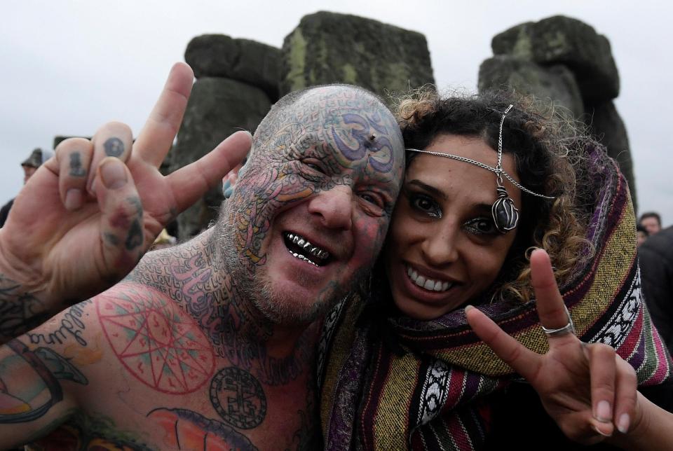  Revellers embraced amid joyful scenes within the prehistoric monument