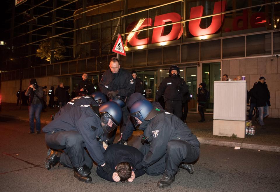 Riot police detain a demonstrator during a vigil of right-wing groups in front of the CDU federal center in Berlin, Germany