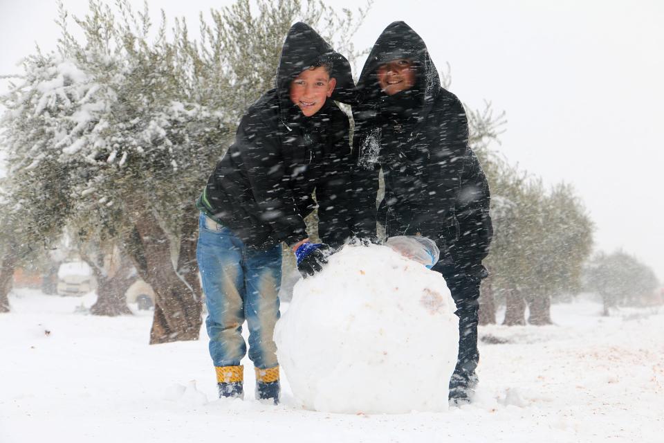  Kids in Azaz making in snowman as snow falls in the tent city