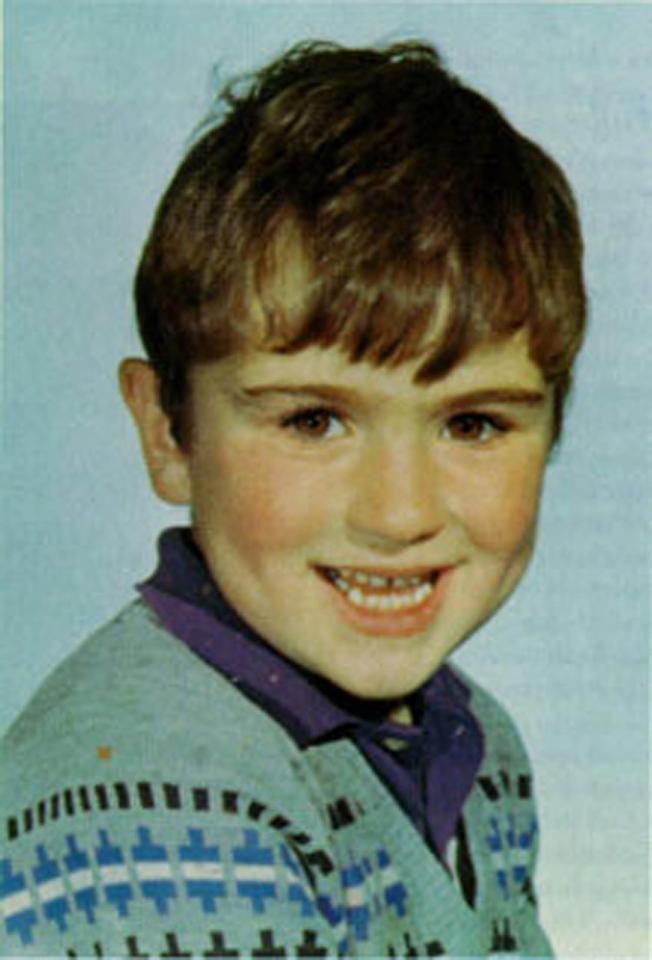  George Michael in a school picture showing off his dimples with a cheeky grin